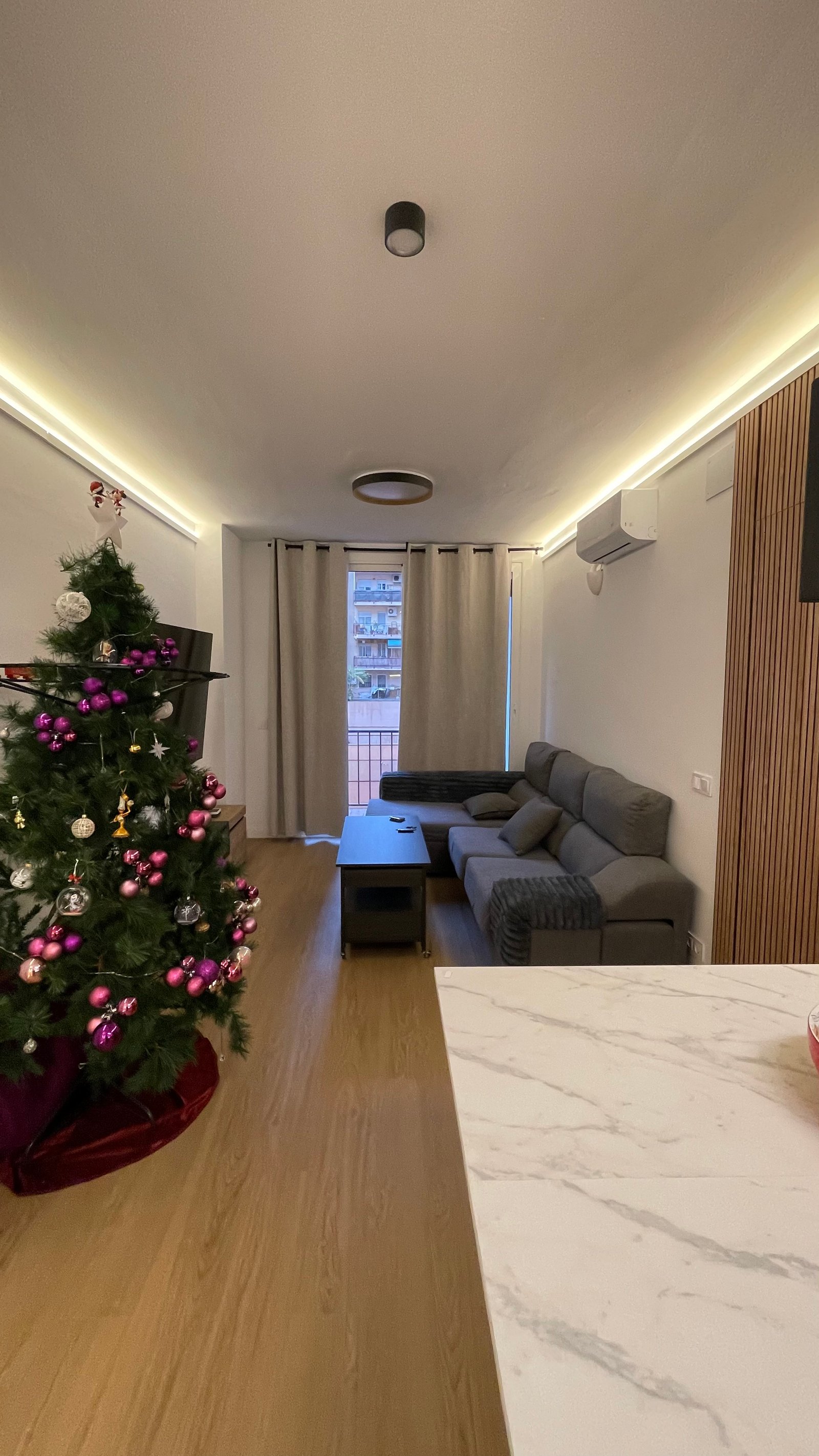 Salón reformado con panel de listones y luz cálida